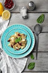 Salad with quinoa, basil and beans served on grey wooden background