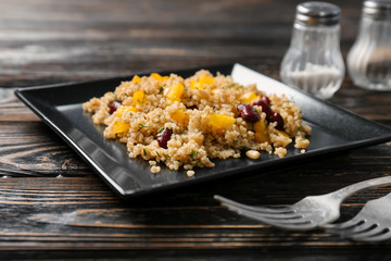Salad with quinoa and beans on wooden background