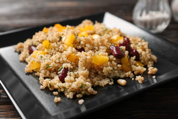 Salad with quinoa and beans on black plate, closeup