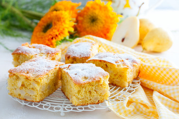 Traditional summer-autumn pie with pears - charlotte with powdered sugar on a white stand, horizontal