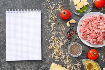 Ingredients for cooking meat lasagna with blank notebook on table, top view