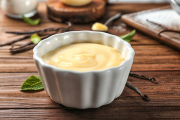 Vanilla pudding in ceramic bowl on wooden table