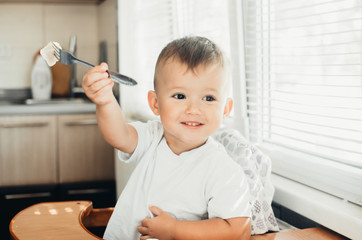 A hungry child is eating dumplings in the kitchen