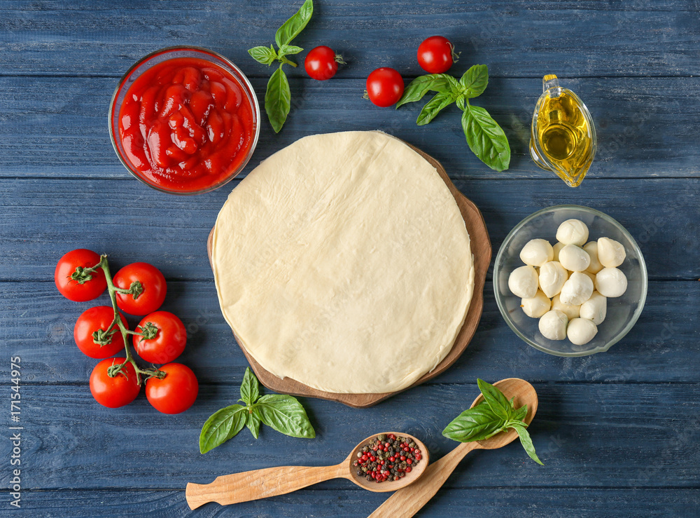 Sticker composition with green fresh basil and ingredients for pizza on wooden background