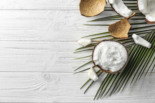 Composition with ripe coconut and oil on wooden background