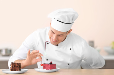Young male chef decorating tasty dessert in kitchen