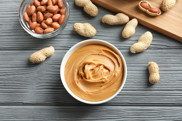 Ceramic bowl with creamy peanut butter on kitchen table
