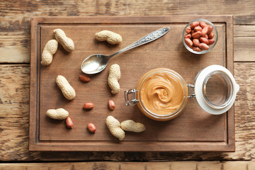 Composition with creamy peanut butter on kitchen table