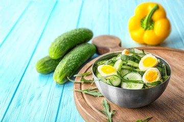 Healthy salad with cucumbers and eggs in bowl on table