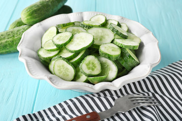 Slices of cucumber in plate on table