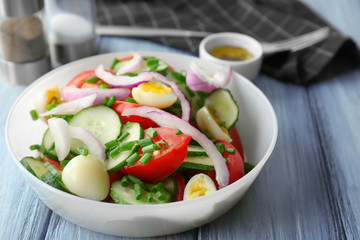 Healthy salad with cucumbers and eggs in bowl on table