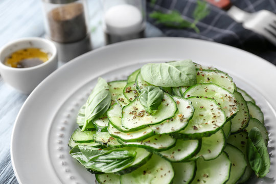 Plate with fresh cucumber salad on table, closeup
