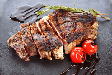 Tasty grilled steak with rosemary on slate plate
