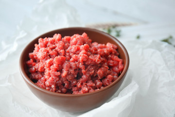 Bowl with fresh forcemeat on table