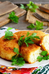 Stuffed vegetarian cutlets on a serving plate. Cutlets prepared from cauliflower and potatoes and stuffed with hard boiled sliced eggs. Closeup. Vertical photo
