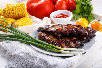 Grilled pork ribs. Meat bbq ribs served with sauce and fresh vegetables.
