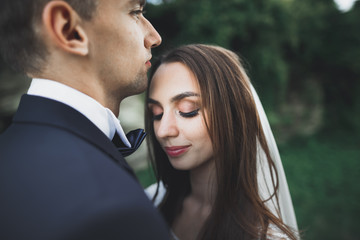 Kissing wedding couple in spring nature close-up portrait