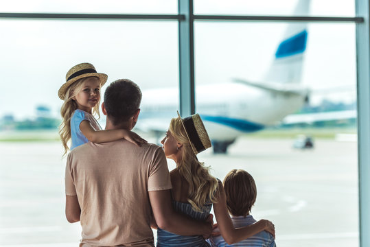 Family Looking Out Window In Airport