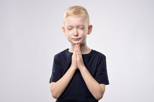 Little caucasian boy with blond hair praying