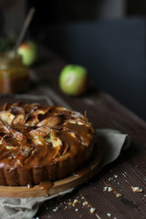 Apple pie with salted caramel on a wooden background