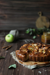 Apple pie with salted caramel on a wooden background