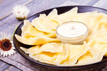 Ukrainian, Russian or Polish dish: varenyky, vareniki, pierogi, pyrohy. Dumplings, filled with cottage cheese (farmer cheese) and served with sour cream, horizontal