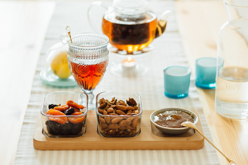 Mixed Nuts and Dried Fruit, Jam, Glass Kettle With Tea. Morning, Breakfast And Healthy Food Concept.