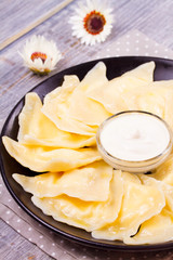 Ukrainian, Russian or Polish dish: varenyky, vareniki, pierogi, pyrohy. Dumplings, filled with cottage cheese (farmer cheese) and served with sour cream, vertical