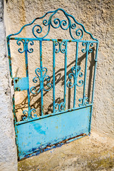Rustic blue metal gate of abandoned building.