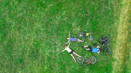 Fototapeten Familienradfahren auf Fahrrädern im Freien Luftaufnahme von oben, glückliche aktive Eltern mit Kind haben Spaß und entspannen sich auf Gras, Familiensport und Fitness © Iuliia Sokolovska