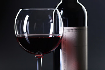 Bottle and glass of red wine .