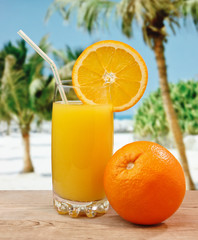 Glass of orange juice on a beach