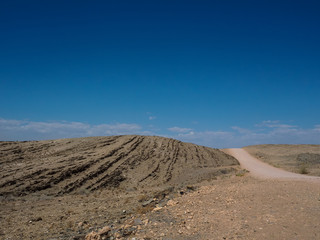 Hot beautiful day on adventure road trip through desert rock mountain landscape route to emptiness with blue sky copyspace background