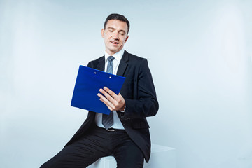Relaxed entrepreneur writing on clipboard