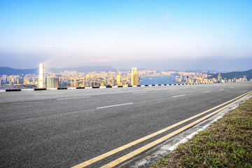 empty asphalt road with cityscape of modern city in blue sky at twilight