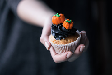 person holding halloween cupcake