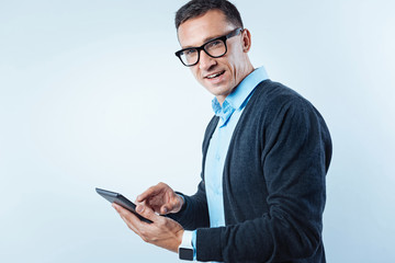 Pensive guy with digital tablet looking into camera