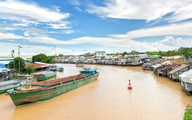 Can Tho, Vietnam - August 25th, 2017: Ships cross the confluence of riverside riverside villages...