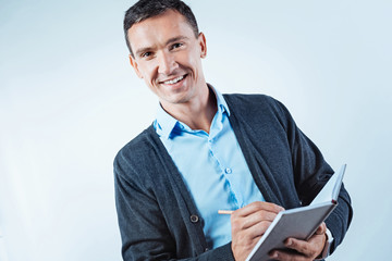Friendly looking man with notebook smiling into camera