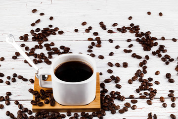 Cup of coffee stands on the beans