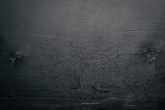 Black textured wooden background. Top view. Free space for text.