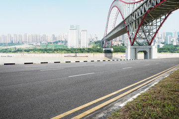 empty asphalt road with steel bridge of modern city