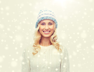 smiling young woman in winter hat and sweater