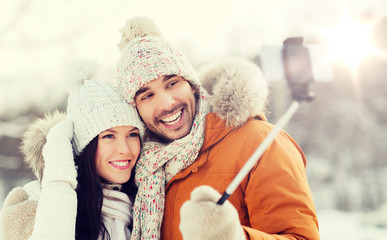 Obraz premium happy couple taking selfie by smartphone in winter