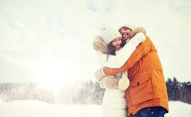 Obraz premium happy couple hugging and laughing in winter