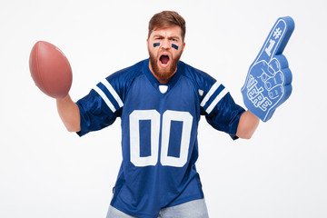 Excited man with rugby ball and fan finger cheering up isolated