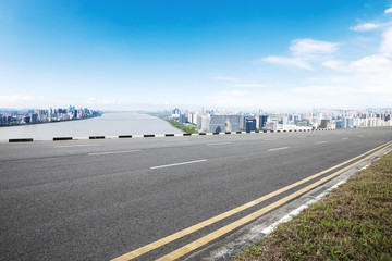 Fototapeta premium pusta droga asfaltowa z nowoczesnymi budynkami w błękitne niebo