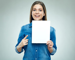 Happy young woman holding sign board pointing finger on copy space.