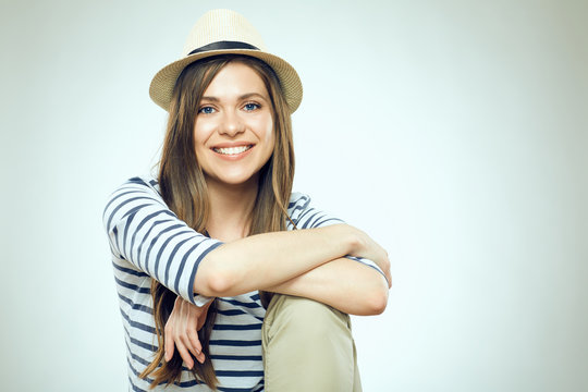 Smiling young woman sitting with folded hands.