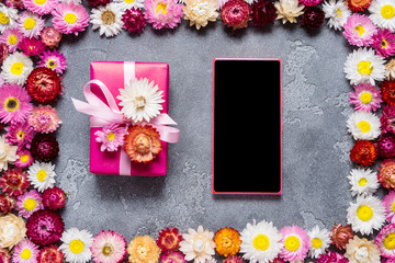 Smart phone and gift box on floral background